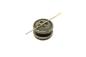 Button side needle minder with pin